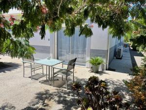 a table and chairs in a patio with a view of the ocean at Chambre luxe dans villa de standing avec piscine, accès discret et indépendant, terrasse arborée et parking privé in La Valette-du-Var
