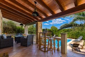 Un patio con mesa y sillas y una piscina. en 2263 Sunny holiday home with views over the bay of Palma, en Badia Gran
