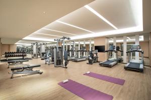 a gym with several treadmills and exercise machines at Holiday Inn Shanghai Dishui Lake by IHG in Nanhui