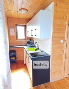 a small kitchen with a sink and a stove at ,,KICZARA" Domki na Punkcie Widokowym w Polańczyku z widokiem na Jezioro Solińskie i góry, domki ogrzewane klimatyzacją ---601--806--454--- in Polańczyk