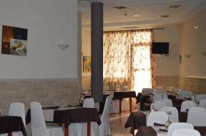 a room with tables and chairs and a large window at Hotel Peña Cruz in Malpartida de Cáceres