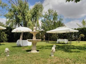 a park with a fountain and two umbrellas at Hotel Peña Cruz in Malpartida de Cáceres