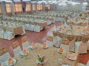a large banquet hall with white tables and chairs at Hotel Peña Cruz in Malpartida de Cáceres