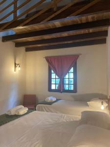 um quarto com 2 camas e uma janela em POUSADA IPIRÃTÃ - Turismo de Vivência Cultural em Soure