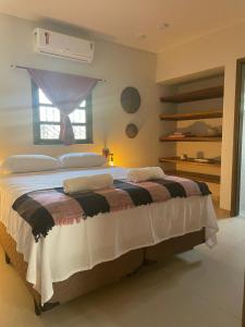 a bedroom with a large bed with a window at POUSADA IPIRÃTÃ - Turismo de Vivência Cultural in Soure