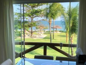 uma vista para o oceano a partir de um quarto com uma janela em Paraíso dos corais Pe na areia em Guarajuba