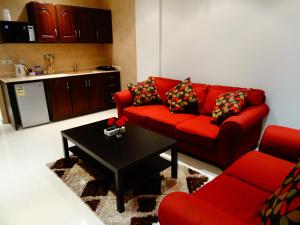 a living room with a red couch and a coffee table at Samaya Al Khobar Hotel Apartments in Al Khobar