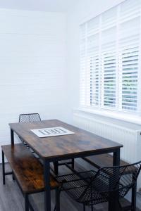 a wooden table and two chairs in front of a window at Magnolia cove in Whitstable