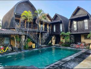 a house with a swimming pool in front of it at Bale Sasak Bungalow in Gili Trawangan