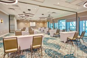 a conference room with tables and chairs and a screen at Holiday Inn Va Beach-Oceanside 21st St, an IHG Hotel in Virginia Beach
