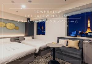 a hotel room with two beds and a couch at Henn na Hotel Tokyo Hamamatsucho in Tokyo