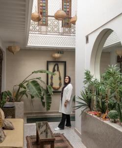 una donna in piedi in una stanza con delle piante di Riad Beata Bed & Breakfast a Marrakech
