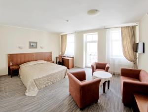 um quarto de hotel com uma cama e duas cadeiras em Grėjaus Namas em Kėdainiai