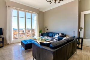 Una sala de estar con sofás y una gran ventana. en Villa Soleil d'Or, en Villefranche-sur-Mer