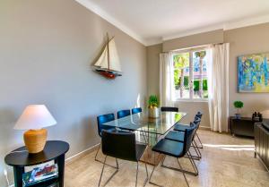 Un comedor con una mesa de cristal y sillas. en Villa Soleil d'Or, en Villefranche-sur-Mer