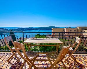a table and chairs on a balcony with a view of the water at Villa Soleil d'Or in Villefranche-sur-Mer