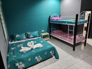 une chambre avec deux lits superposés avec des serviettes sur le lit dans l'établissement Tok Abu Heritage Roomstay, à Pantai Cenang 45 autres photos