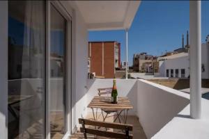 a bottle of wine on a wooden table on a balcony at Apartment close to the beach in Sant Adria de Besos