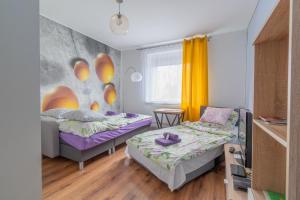 una camera con due letti e un divano di Apartament Morcinka a Bytom