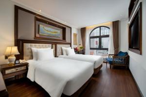 a hotel room with two beds and a window at The Q Hotel in Hanoi