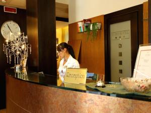 a woman sitting at a reception desk with a laptop at Euro Hotel in Pieve Santo Stefano