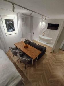 a living room with a table and a bath tub at Apartamenty MUNN 1 Szczecin in Szczecin