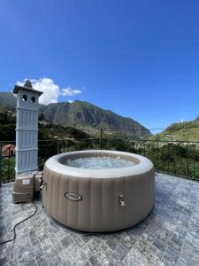 a hot tub on a patio with mountains in the background at Villa Bella Vista by Atlantic Holiday in São Vicente