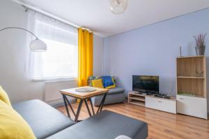 uma sala de estar com um sofá e uma mesa em Apartament Morcinka em Bytom