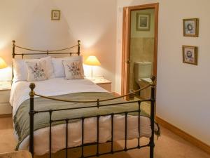 a bedroom with a bed and two lamps and a mirror at Beckside Cottage in Bishop Monkton