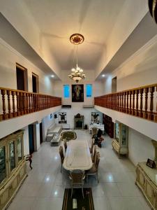 Blue Guest House في Samtredia: غرفة معيشة كبيرة مع طاولة وكراسي