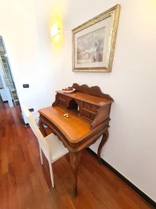 Elle comprend un bureau en bois avec une chaise blanche et une table. dans l'établissement LE MURA, à Gênes