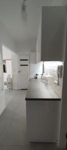 a kitchen with white cabinets and a counter top at Apartament w samym centrum in Warsaw