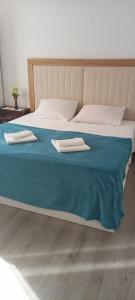 uma cama com um cobertor azul e duas toalhas em Apartment Silvana em Šibenik