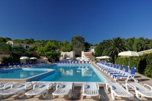 a swimming pool with lounge chairs and umbrellas at Baia Degli Aranci Suite & Apartments in Vieste