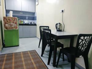 una cucina con tavolo e sedie in una stanza di HOMESTAY KAMPUNG DELEK BARU, KLANG a Kampong Telok Gadong Kechil