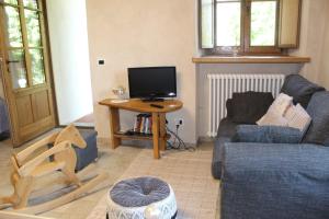 德羅內羅的住宿－Appartamento del Monastero，客厅配有沙发和带电视的桌子