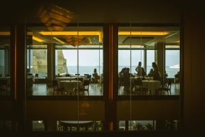 a group of people sitting at tables in a restaurant at Hotel Royal Continental in Naples