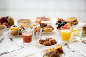 a table with plates of breakfast foods and drinks at Hotel Royal Continental in Naples