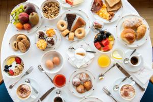 a white table with many plates of breakfast foods at Hotel Royal Continental in Naples