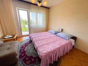 a bedroom with a large bed and a window at Apartman Asta in Jadranovo