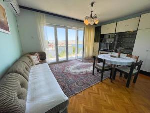 a living room with a couch and a table at Apartman Asta in Jadranovo