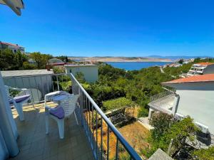 a balcony with two chairs and a view of the water at Apartman Asta in Jadranovo