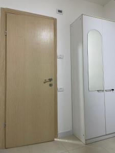 una puerta de madera en una habitación junto a un armario blanco en Alsharif family, en Hebron