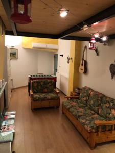a living room with two couches and a guitar at Underground Haven and free parking in Bardonecchia
