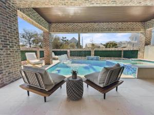 a patio with two chairs and a swimming pool at Summer Wind home in Seagrove Beach