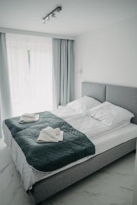 1 dormitorio con 1 cama grande y 2 toallas. en Norwida 17, en Międzyzdroje