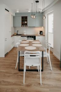 a kitchen with a table and white chairs at Norwida 17 in Międzyzdroje