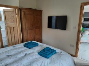 a bedroom with two blue towels on a bed at Ty Carreg Bach in Llanrwst