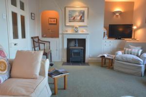 a living room with a couch and a fireplace at Crabbe House in Aldeburgh