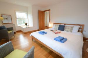 a bedroom with a large white bed with blue towels on it at Vesta Cottage, Orford in Orford